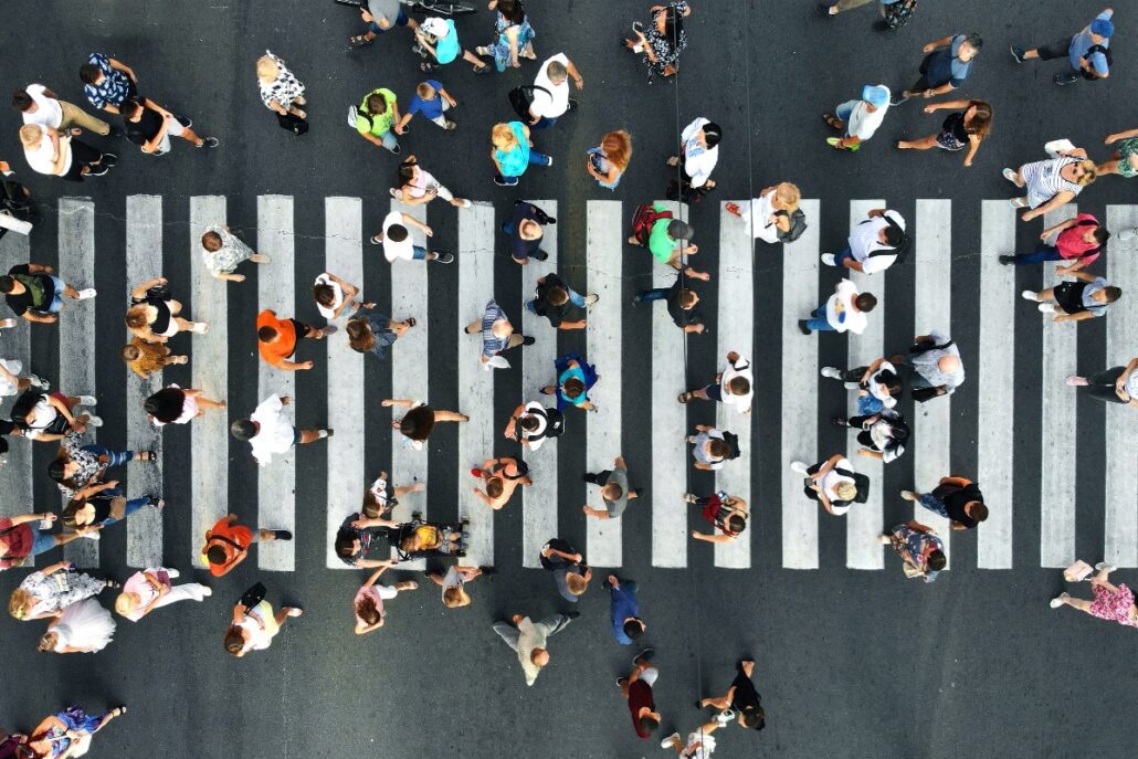 Aerial view of many people walking along a crosswalk